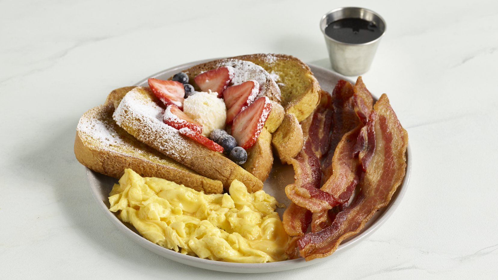 French Toast Combo with berries, whipped cream, eggs and bacon